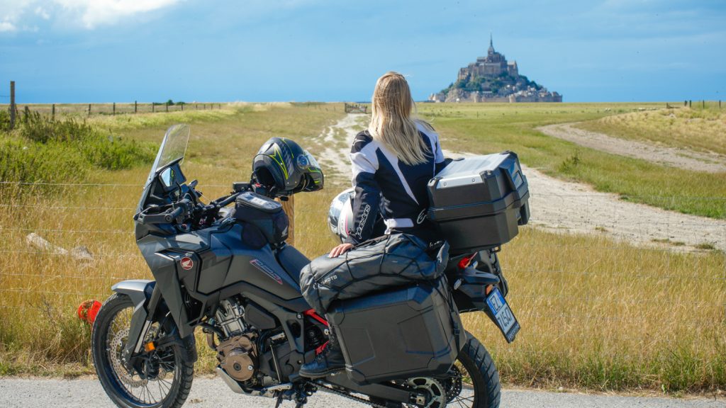 ragazzi su una moto che guarda le mont saint Michel in Normandia