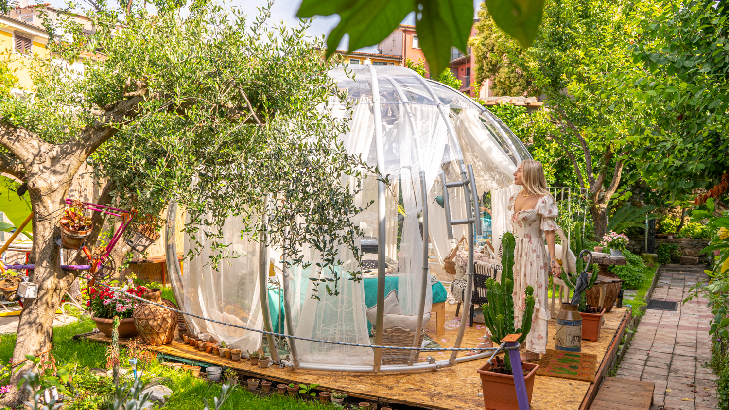 ragazza che si trova in una giardino incantata ed entra in una bubble room in toscana a Carrara